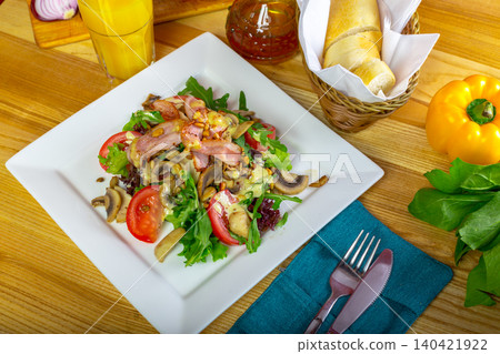 Fresh salad with vegetables and grilled meat served on a table with bread and a drink 140421922