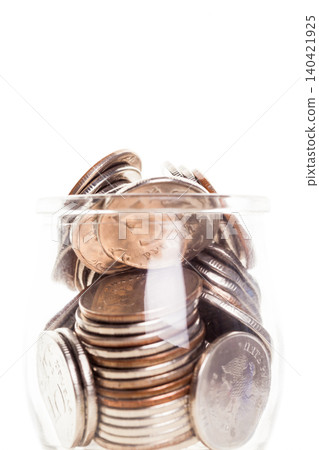 Coins are stacked inside a clear glass jar on a white background for saving or counting Coins are stacked inside a clear glass jar on a white background for saving or counting 140421925
