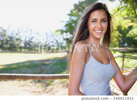 Woman, ranch and portrait outdoor, nature park and confidence on holiday in summer break in sunshine. Female person, countryside and happy by fence, vacation and farm with smile for relaxation 140421931