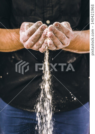 Hands pour flour as part of food preparation in a kitchen setting during daytime Hands pour flour as part of food preparation in a kitchen setting during daytime 140421968