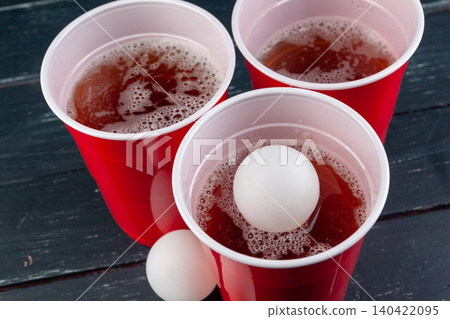 Wooden table with red cups and ball for beer pong Wooden table with red cups and ball for beer pong 140422095
