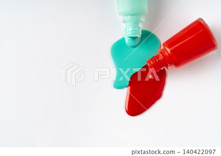 Nail polishes spilled out of bottles on white background 140422097