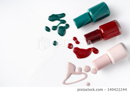 Bright colored nail polish bottles with drippings on white background Bright colored nail polish bottles with drippings on white background 140422244