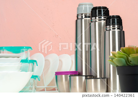 Thermos bottle against tableware in a kitchen Thermos bottle against tableware in a kitchen 140422361
