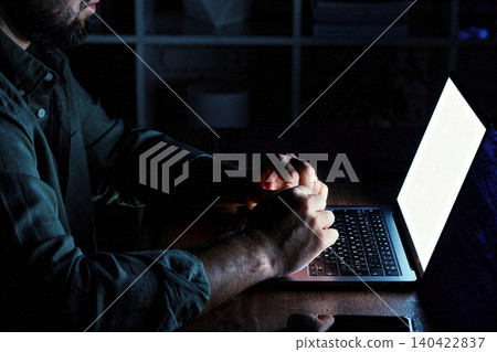 Person works on laptop in dark room during late night hours Person works on laptop in dark room during late night hours 140422837
