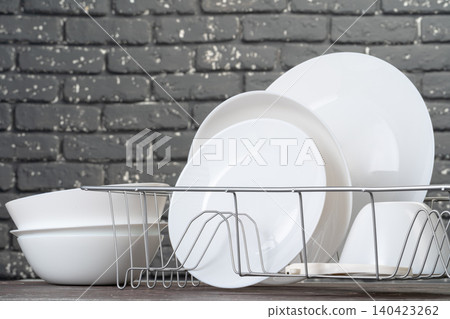 Dish rack with clean dry dishes on kitchen counter 140423262