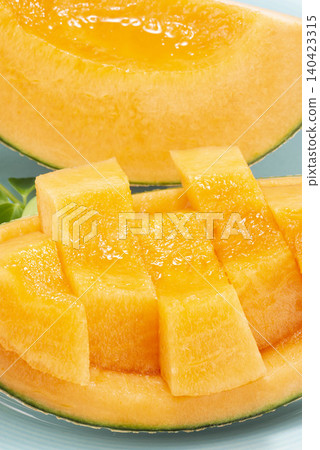A cross-section of fresh fruit, with glistening melon flesh and a sweet aroma. 140423315
