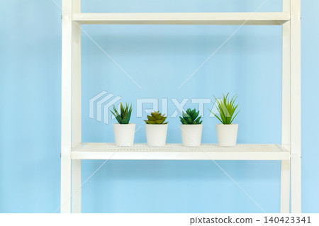 White metal rack with books against blue background White metal rack with books against blue background 140423341