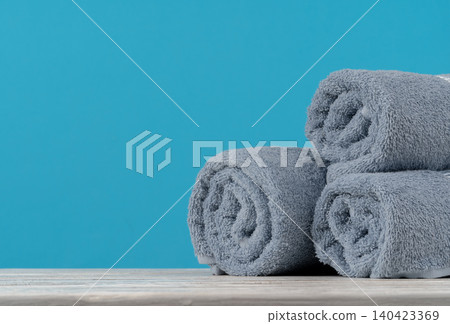 Stack of rolled towels on a wooden table 140423369
