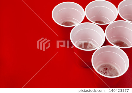 Cups and plastic ball on red background. Beer pong game Cups and plastic ball on red background. Beer pong game 140423377