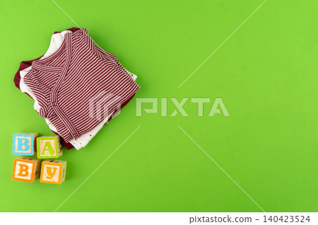 Top view of baby clothes on green background Top view of baby clothes on green background 140423524