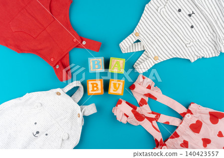 Top view of baby clothes on blue background Top view of baby clothes on blue background 140423557