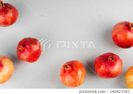 Ripe pomegranates on a light gray kitchen table Ripe pomegranates on a light gray kitchen table 140423561