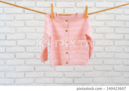 Washing of baby clothes pinned on a rope to dry Washing of baby clothes pinned on a rope to dry 140423607