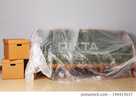 Packed household stuff in boxes and packed sofa for moving Packed household stuff in boxes and packed sofa for moving 140423637