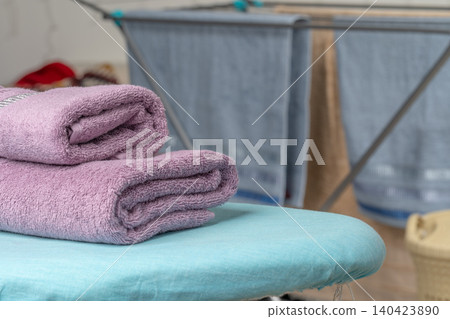 Housework concept. Ironing towels on ironing board Housework concept. Ironing towels on ironing board 140423890
