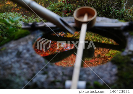 The autumn leaves of the maple trees in the garden of a temple in Kamitakano, Kyoto, are reflected in the water of a water basin. The autumn leaves of the maple trees in the garden of a temple in Kamitakano, Kyoto, are reflected in the water of a water basin. 140423921