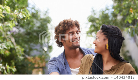 Interracial, couple and smile together in nature, happy and love in diversity people with tree in backyard. Happiness, affection or staring, outdoor for relationship growth or commitment for romance 140424012