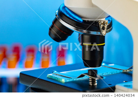 Close up photo of microscope with test tubes with blood samples Close up photo of microscope with test tubes with blood samples 140424034