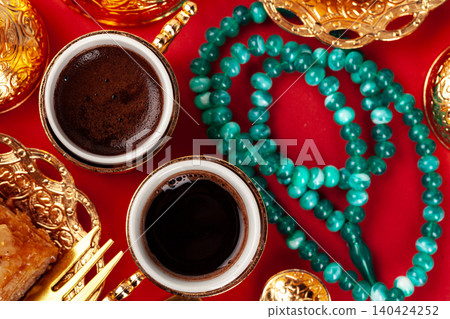 Turkish baklava and coffee in oriental dishware on red background Turkish baklava and coffee in oriental dishware on red background 140424252
