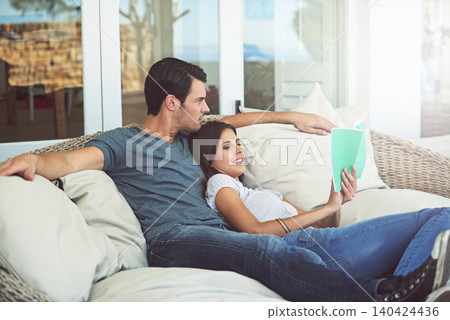 Couple, relax and book on patio, love and chair to relax and dating on couch for learning. Man, woman and romance while happy, smile and reading for entertainment and together in living room Couple, relax and book on patio, love and chair to relax and dating on couch for learning. Man, woman and romance while happy, smile and reading for entertainment and together in living room 140424436