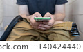 Man sitting on the toilet with a smartphone in hands. Guy scrolling phone on the loo, concept of prolonged sitting risk, screen addiction, and hemorrhoids. Man sitting on the toilet with a smartphone in hands. Guy scrolling phone on the loo, concept of prolonged sitting risk, screen addiction, and hemorrhoids. 140424440