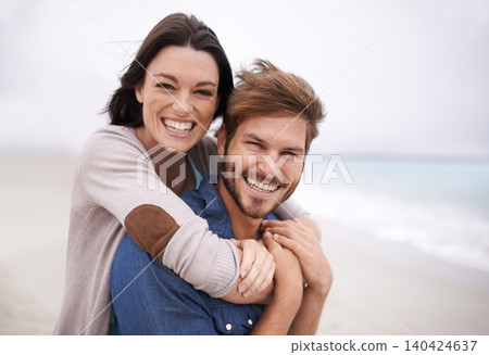 Couple, portrait and hug with happiness at beach for holiday, vacation and honeymoon with love, relationship and outdoor on seascape. Newlyweds, lovers and people excited for marriage together 140424637