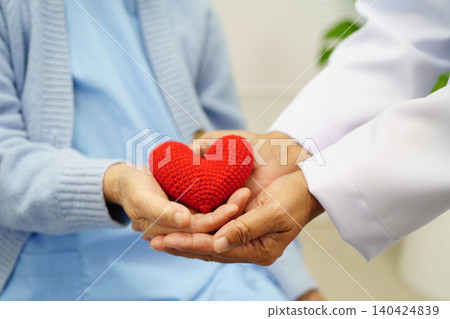 Asian elder senior woman patient holding red heart in hospital. 140424839