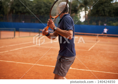Tennis, game and man training for sport, competition or exercise for fitness on court. Athlete, workout and play on pitch outdoor in summer with action, challenge and person in contest from back Tennis, game and man training for sport, competition or exercise for fitness on court. Athlete, workout and play on pitch outdoor in summer with action, challenge and person in contest from back 140424850