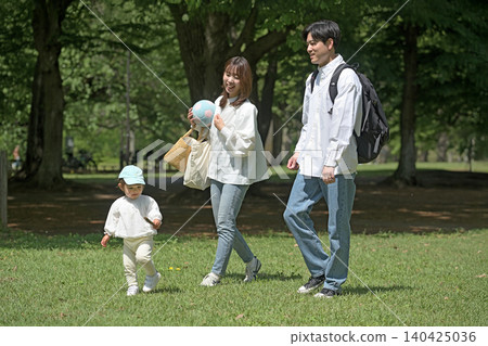 Young family taking a walk in the park Young family taking a walk in the park 140425036