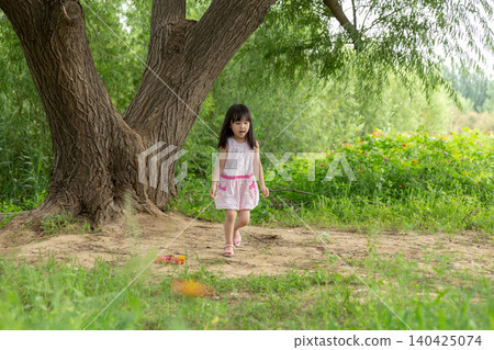 Asian Little Girl Walking Alone in Green Nature Park Under Tree Asian Little Girl Walking Alone in Green Nature Park Under Tree 140425074