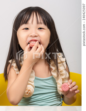 Cute Chinese girl enjoying a delicious foods, tasting food with pleasure. Cute Chinese girl enjoying a delicious foods, tasting food with pleasure. 140425097