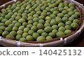 Green plums spread out on a sieve 140425132