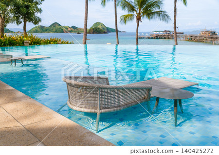 Luxury resort poolside seating in tropical waterfront destination 140425272