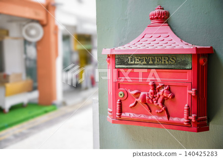 Vintage red mailbox on wall with decorative horse detail Vintage red mailbox on wall with decorative horse detail 140425283