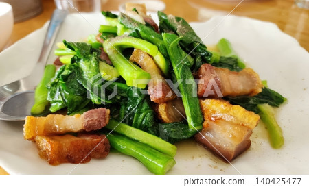 Stir Fried Chinese Kale with Crispy Pork Belly on White Plate Stir Fried Chinese Kale with Crispy Pork Belly on White Plate 140425477