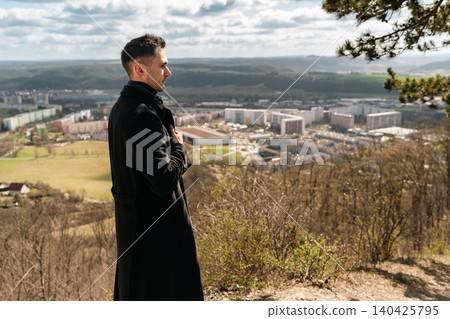 Man Standing Above City and Green Valley Man Standing Above City and Green Valley 140425795