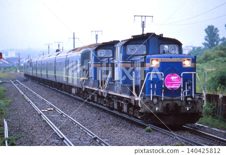 暮光特快臥舖列車在雨中沿著室蘭本線行駛。 暮光特快臥舖列車在雨中沿著室蘭本線行駛。 140425812