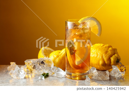 Classic iced black tea in tall glass with lemon wedges, ice cubes and mint leaves. Classic iced black tea in tall glass with lemon wedges, ice cubes and mint leaves. 140425942