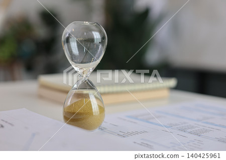 Close up of hourglass timer which run out on office desk for deadline concept. 140425961
