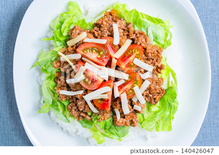 A photo of taco rice, an Okinawan dish with cheese, lettuce, and tomatoes. A photo of taco rice, an Okinawan dish with cheese, lettuce, and tomatoes. 140426047