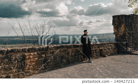 Stylish Man Standing by Historic Stone Wall Stylish Man Standing by Historic Stone Wall 140427211