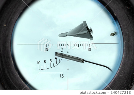 Strike drone observed through optical scope against sky as aerial security threat. Strike drone observed through optical scope against sky as aerial security threat. 140427218