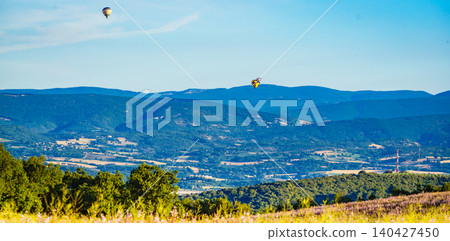 Hot air balloons float above hills and fields in the countryside. Provence in France 140427450