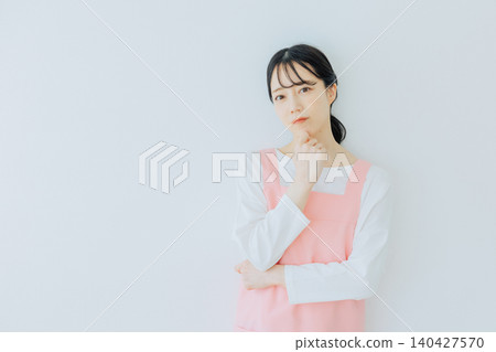 A female childcare worker with a troubled expression A female childcare worker with a troubled expression 140427570