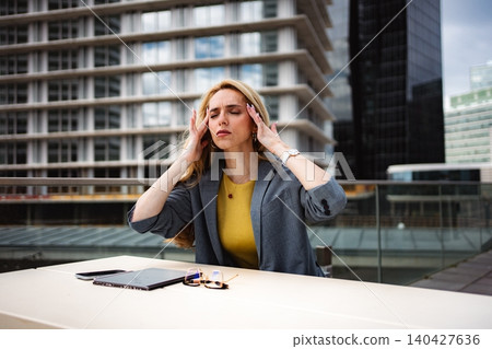 Businesswoman having headache suffering from stress and burnout at office Businesswoman having headache suffering from stress and burnout at office 140427636