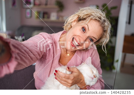 Adult woman smiling taking selfie with white cat 140428235