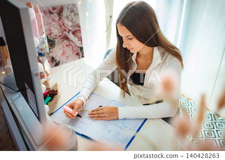 Teenager girl studying at desk highlighting school notebook Teenager girl studying at desk highlighting school notebook 140428263
