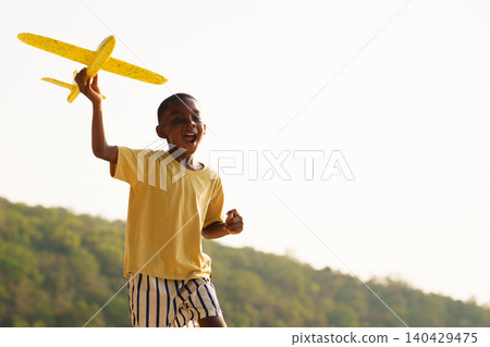Happy Black boy running with toy airplane on the beach Happy Black boy running with toy airplane on the beach 140429475
