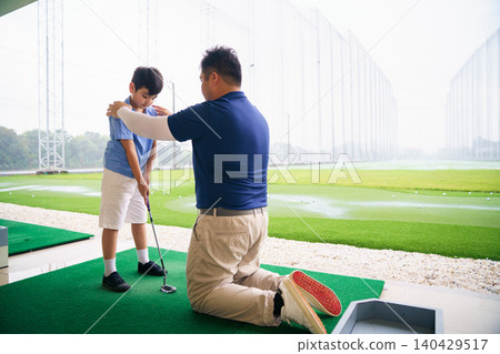 Professional golf coach teaching basic grip to young boy Professional golf coach teaching basic grip to young boy 140429517
